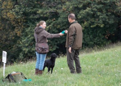 Educatrice e conduttore con cane nero durante una lezione di addestramento